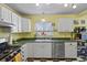 Bright kitchen with white cabinets, a gas range, and stainless steel dishwasher at 3941 S Elati St, Englewood, CO 80110