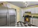 Bright kitchen boasts stainless steel appliances, white cabinets, and yellow walls at 3941 S Elati St, Englewood, CO 80110