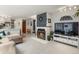 Open-concept living room with a cozy fireplace, neutral decor, and a view to the kitchen at 3941 S Elati St, Englewood, CO 80110