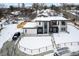 Aerial view of a modern home surrounded by snow-covered landscaping and mature trees in a serene setting at 5258 Lions Paw St, Castle Rock, CO 80104