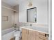 Bathroom with tub and shower combo, light wood cabinets, white countertops, and stylish bronze fixtures at 5258 Lions Paw St, Castle Rock, CO 80104