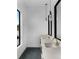 Modern bathroom featuring double sinks with gold fixtures, pendant lighting, and black-framed mirrors at 5258 Lions Paw St, Castle Rock, CO 80104