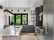 This modern kitchen features gray cabinetry, a large center island, pendant lighting, and backyard views at 5258 Lions Paw St, Castle Rock, CO 80104