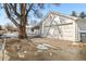 View of the 2-car detached garage from street with mature tree and snowy ground at 4100 Fenton St, Denver, CO 80212