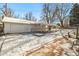 A detached two-car garage is surrounded by winter landscaping and a brick pathway at 4100 Fenton St, Denver, CO 80212