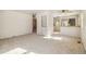 Bright living room with neutral carpet, built-in shelving, and view into the kitchen at 4100 Fenton St, Denver, CO 80212