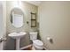 Powder room features pedestal sink, decorative wall shelves, and wood-look flooring at 16285 W 62Nd Ln # C, Arvada, CO 80403
