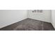Neutral-toned bedroom features modern carpet, white walls, a window for natural light, and a vent at 16285 W 62Nd Ln # C, Arvada, CO 80403
