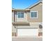 Townhome exterior has tan siding, a white garage door, and a DirectTV satellite dish at 16285 W 62Nd Ln # C, Arvada, CO 80403