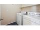 Convenient laundry area includes a washer, dryer, and shelf above on a neutral painted wall at 16285 W 62Nd Ln # C, Arvada, CO 80403