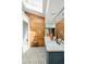Bright bathroom featuring skylight, wood paneled wall, double sink, and tiled floors at 1662 S Eudora St, Denver, CO 80222