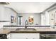 Close up of the kitchen counter showcasing stainless steel sink, black faucet, and modern white cabinets at 1662 S Eudora St, Denver, CO 80222