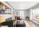 Cozy living room featuring a leather couch, large windows, and an open view to the updated kitchen at 1662 S Eudora St, Denver, CO 80222