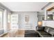 Bright living room with hardwood floors, a leather couch, and an open view to the front door and kitchen at 1662 S Eudora St, Denver, CO 80222