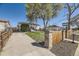 View of the home with well-maintained yard, fence, and driveway leading to the house at 2448 S Galapago St, Denver, CO 80223