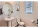 Powder room featuring a pedestal sink, a round mirror and a window with white blinds at 24374 E 42Nd Ave, Aurora, CO 80019