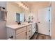 Bright bathroom featuring double sinks, a large mirror with vanity lighting, and modern fixtures at 24374 E 42Nd Ave, Aurora, CO 80019