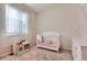 A charming Bedroom featuring a white crib, pink accents, and a cute toy kitchen for imaginative play at 24374 E 42Nd Ave, Aurora, CO 80019