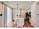 Stylish kitchen featuring a central island with seating, stainless steel appliances, and wood-look flooring at 24374 E 42Nd Ave, Aurora, CO 80019
