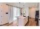 Elegant kitchen island with a sink, pendant lighting, and a view of the kitchen and living area at 24374 E 42Nd Ave, Aurora, CO 80019