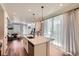 Open-concept kitchen with quartz countertops, stainless appliances, and a view of the living area and large windows at 24374 E 42Nd Ave, Aurora, CO 80019
