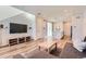 Bright living room with wood floors, a TV, and open access to the kitchen at 24374 E 42Nd Ave, Aurora, CO 80019