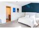 Bright bedroom featuring a white bed set against a blue accent wall and attached bathroom at 992 Burning Bush Pt, Monument, CO 80132