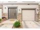 Beautiful townhome showcasing a private entrance, attached garage, stone accents, and manicured landscape at 992 Burning Bush Pt, Monument, CO 80132
