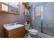 Practical bathroom featuring a single vanity, wooden shelves, and a step-in shower with glass doors at 4369 E 127Th Way, Thornton, CO 80241