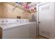 Functional laundry room with a side-by-side washer and dryer, shelving, and extra storage space at 4369 E 127Th Way, Thornton, CO 80241