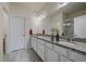 Bathroom featuring double sinks with granite counters, a large mirror, and a glass-enclosed shower at 15476 W 64Th Loop # C, Arvada, CO 80007