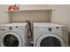 Bright laundry room featuring a modern washer and dryer set for convenient laundry tasks at 15476 W 64Th Loop # C, Arvada, CO 80007