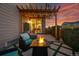 Relaxing outdoor patio with fire pit, pergola, and well-manicured landscaping at twilight at 8846 Yates Dr, Westminster, CO 80031