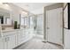 Modern bathroom with double vanity, decorative mirrors, and tiled shower with glass doors at 8846 Yates Dr, Westminster, CO 80031