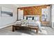 Cozy bedroom featuring a king bed, wood accent wall, and natural light from the dual windows at 8846 Yates Dr, Westminster, CO 80031