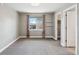 A bedroom with a big window, two shelves, gray walls, and gray carpet at 8846 Yates Dr, Westminster, CO 80031