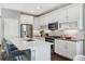 Modern kitchen featuring white cabinets, stainless steel appliances, island seating, and stylish backsplash at 8846 Yates Dr, Westminster, CO 80031