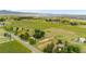 Expansive aerial view of acreage with lush green pastures, scattered trees and mountain views in the distance at 7583 W Trail South Dr, Littleton, CO 80125