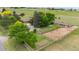 Aerial view of horse property with house, barn, riding area, mature trees, and garden area at 7583 W Trail South Dr, Littleton, CO 80125