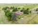 Aerial view of the property and yard, featuring mature trees, a horse paddock and surrounding fences at 7583 W Trail South Dr, Littleton, CO 80125