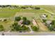 Expansive aerial view of a home with mature trees, horse property, and views of green pastures at 7583 W Trail South Dr, Littleton, CO 80125