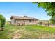 Exterior view of tan barn on a grassy lot with fences and mountain views at 7583 W Trail South Dr, Littleton, CO 80125