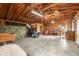 Large unfinished barn with concrete floor, wood ceiling and lawn equipment at 7583 W Trail South Dr, Littleton, CO 80125