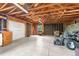 Large unfinished barn with concrete floor, wood ceiling and lawn equipment at 7583 W Trail South Dr, Littleton, CO 80125