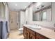 Bathroom with a stand up shower, toilet and vanity with mirror and overhead lighting at 7583 W Trail South Dr, Littleton, CO 80125