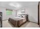 Comfortable bedroom with a bed covered with a striped comforter and a window for natural light at 7583 W Trail South Dr, Littleton, CO 80125