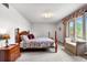 Cozy bedroom featuring a four-poster bed, soft lighting, and a comfortable sitting area by the window at 7583 W Trail South Dr, Littleton, CO 80125