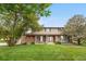 Charming two-story home featuring brick accents, complemented by a well-manicured lawn and mature trees at 7583 W Trail South Dr, Littleton, CO 80125