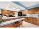 Well-lit kitchen boasting wooden cabinets, a spacious breakfast bar, and modern appliances at 7583 W Trail South Dr, Littleton, CO 80125