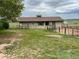 Tan outbuilding or barn with fenced paddock and a weather vane on the roof at 7583 W Trail South Dr, Littleton, CO 80125